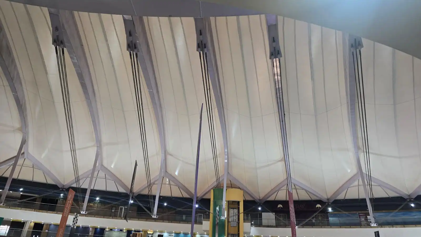 Vasant Square Mall, Vasant Kunj — looking up into the central court at the translucent tensile membrane roof on its radial mast-and-cable structure, Ekra Decor